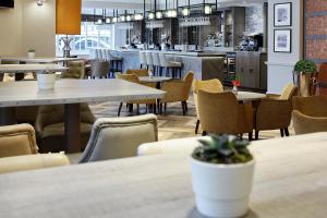 a restaurant with tables and chairs and a bar at Sir Christopher Wren Hotel in Windsor
