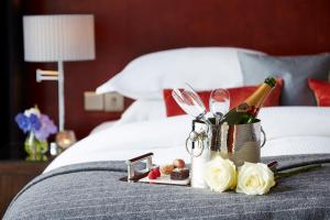 a tray with a bottle of champagne and flowers on a bed at Ice House Hotel in Ballina