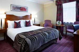 a hotel room with a bed and two chairs at Sir Christopher Wren Hotel in Windsor