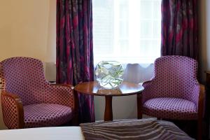 a room with two chairs and a table with a vase on it at Sir Christopher Wren Hotel in Windsor