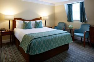 a hotel room with a bed and two chairs at Sir Christopher Wren Hotel in Windsor