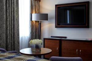 a hotel room with a bed and a tv and a table at Sir Christopher Wren Hotel in Windsor