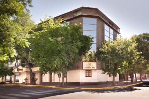 un edificio en una calle con árboles delante en Hotel Carollo en Mendoza