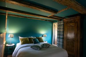 a bedroom with blue walls and a large bed at Le B. VINTAGE in Riquewihr