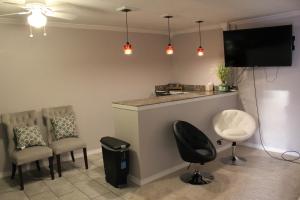 a room with a bar with chairs and a tv at Brydan Suites in Eureka Springs