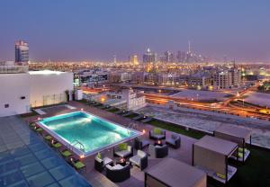 a pool on the roof of a building with a city at The Canvas Dubai - MGallery Hotel Collection in Dubai