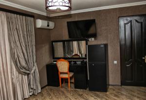 ein Zimmer mit Schreibtisch, Stuhl und Fernseher in der Unterkunft Hotel Obola in Samtredia