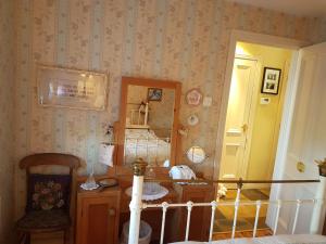 ein Zimmer mit einem Tisch und einem Stuhl und einem Spiegel in der Unterkunft Ros Cottage in Carlingford