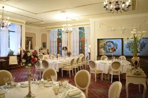 uma sala de jantar com mesas e cadeiras brancas em Hotel Radmilovac em Belgrado