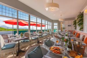 a restaurant with tables and chairs and windows at Butler Arms Hotel in Waterville