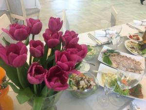 a table with purple tulips in a vase on it at Grota Bochotnicka in Kazimierz Dolny