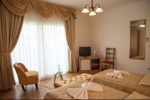 a bedroom with two beds and a chair and a window at Villa Kula in Trogir