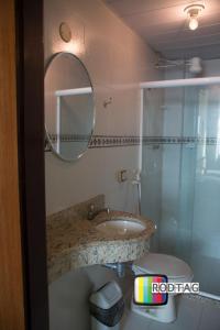 a bathroom with a sink and a mirror at Hotel Porto Da Barra in Salvador