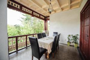a dining room with a table and chairs on a balcony at Vila Lili in Băile Govora