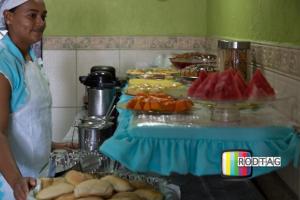 a woman standing in front of a buffet of food at Hotel Porto Da Barra in Salvador