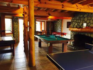a room with a pool table and a fireplace at Encanto del Rio in Villa La Angostura