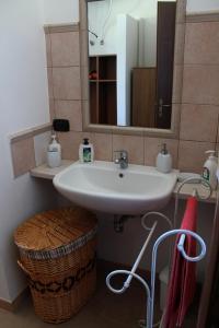 Tenuta Foderaro في Amaroni: حمام مع حوض ومرآة وسلة