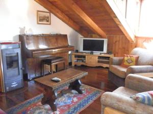 ein Wohnzimmer mit einem Klavier und einem TV in der Unterkunft Mont Blanc Top Floor in La Salle
