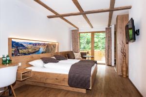 a bedroom with a large bed and a tv at Gasthof Weißes Rössl in Mühldorf