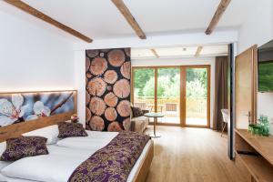 ein Schlafzimmer mit einem großen Bett und einem Balkon in der Unterkunft Gasthof Weißes Rössl in Mühldorf