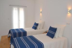 duas camas com lençóis azuis e brancos num quarto em TP BOMBARDA 5, Lisbon Deluxe Apartment em Lisboa