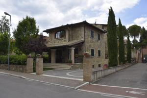 a large stone house on the side of a street at La Torre House in San Quirico dʼOrcia