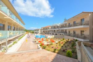 an apartment building with a patio and a swimming pool at Karras Grande Resort in Tsilivi