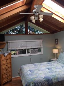 a bedroom with a bed and a ceiling fan at Secret Garden Inn & Cottages in Santa Barbara