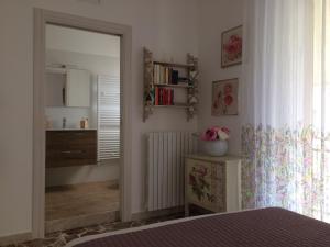a bedroom with a mirror and a dresser and a room at Il Piccolo Attico 2 in Caltagirone