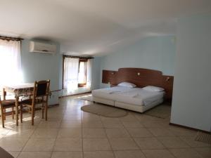 1 dormitorio con 1 cama, mesa y sillas en Guestrooms Hema, en Sozopol