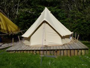 a white tent sitting on top of a wooden deck at Inver Coille Campsite in Fort Augustus