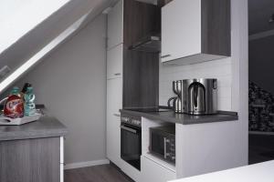 a kitchen with a stove top oven next to a staircase at Ferienwohnung im Schellenpark in Tarp