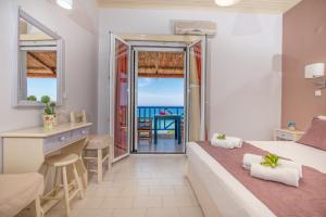 a bedroom with a bed and a view of the ocean at Blue House Apartments in Vasilikos