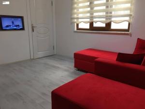 a living room with a red couch and a window at Yıldız Pansiyon in Amasra +17 photos