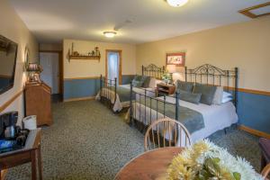 a hotel room with two beds and a table at Stroudsmoor Country Inn in Stroudsburg