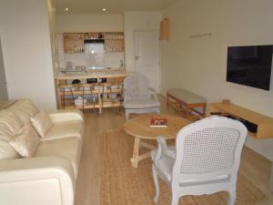 sala de estar con sofá, mesa y sillas en King Fisher 6, en Mossel Bay