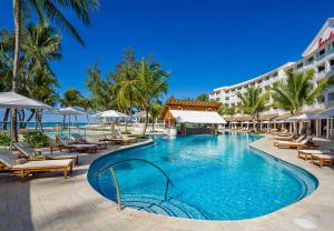 基督堂區的住宿－Sandals Barbados All Inclusive - Couples Only，度假村的游泳池,配有椅子和遮阳伞