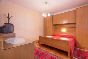 a bedroom with a bed with a red bedspread at Apartments Silvia in Poreč