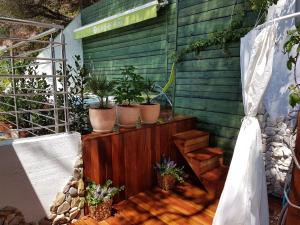 eine Terrasse mit Topfpflanzen an einer Holzwand in der Unterkunft Apartments Mistral in Mimice