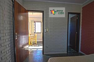 an open door to a room with a brick wall at Pura Vida Residence in Morretes