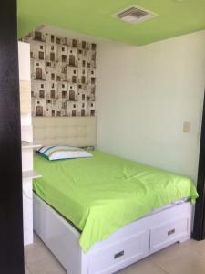 a bedroom with a bed with a green comforter at Torre Bellini in Guayaquil +29 photos