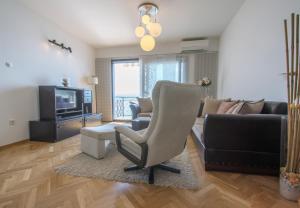 ein Wohnzimmer mit einem Sofa und einem Stuhl in der Unterkunft Apartment Ranch in Opatija