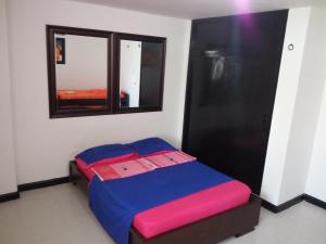 a small bed in a room with a window at Playa Los Cocos in Santa Marta