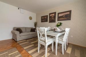 a living room with a table and chairs and a couch at Apartments & Rooms Aleksandra in Bled