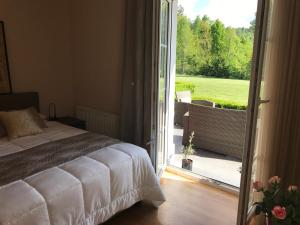 a bedroom with a bed and a door to a patio at Linden Garden Apartment in Postojna