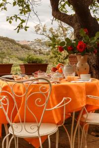 ビッボーナにあるLocanda Etruscaのオレンジのテーブルクロスと花が飾られたテーブル