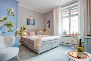 a bedroom with a bed and a chair and a table at Apartamenty Chełmno in Chełmno
