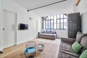 ein Wohnzimmer mit einem Sofa und 2 Tischen in der Unterkunft Sloth Loft Montmartre in Paris