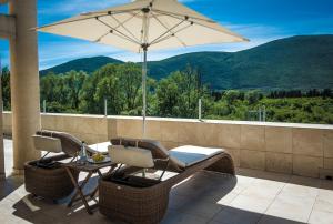 a patio with a table and chairs and an umbrella at Hotel Odissey Jaz in Budva