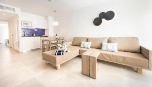 a living room with a couch and a table at Seaclub Alcudia Mediterranean Resort in Port d'Alcudia